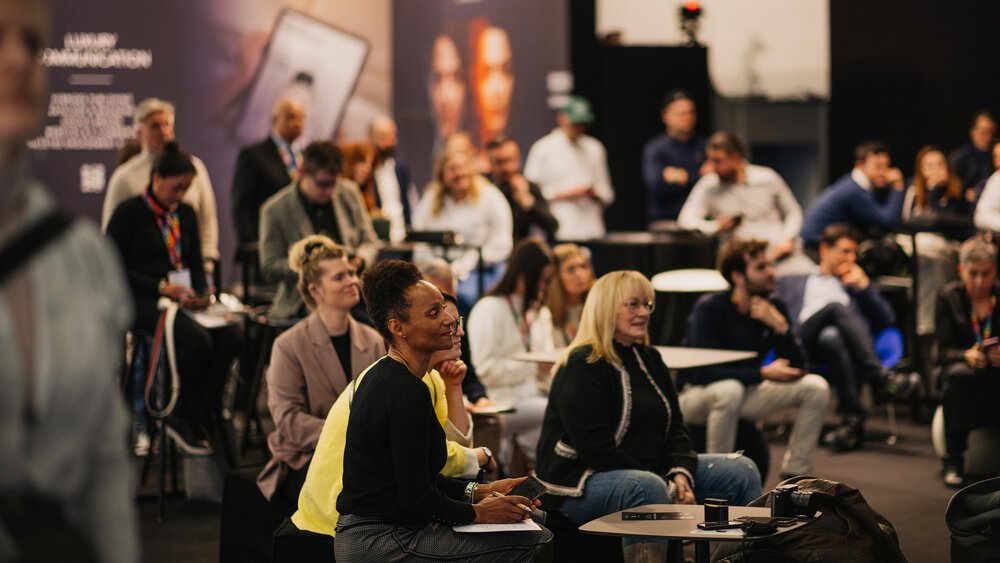 A large audience in a presentation area at INHORGENTA listens intently to a speaker outside the frame.