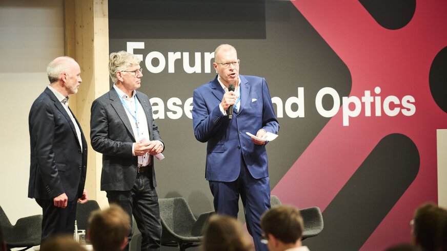Prof. Dr. Andreas Tünnermann, Hans-Dieter Hoffmann, Dr. Thomas Rettich on stage of Forum Lasers and Optics 2025