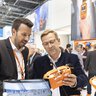 A male exhibitor and a male visitor at IFAT Munich talking about a product