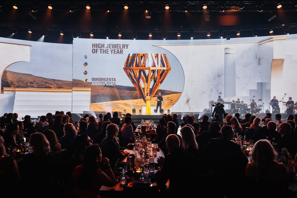 The audience sits at a gala in front of a stage with a large screen on which the INHORGENTA AWARD trophy can be seen.
