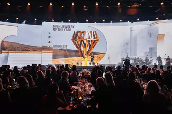 The audience sits at a gala in front of a stage with a large screen on which the INHORGENTA AWARD trophy can be seen.