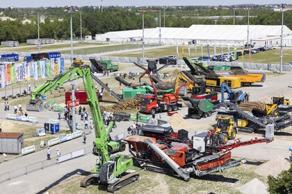 Aerial view of an area of the open-air grounds where several construction machines are on display.
