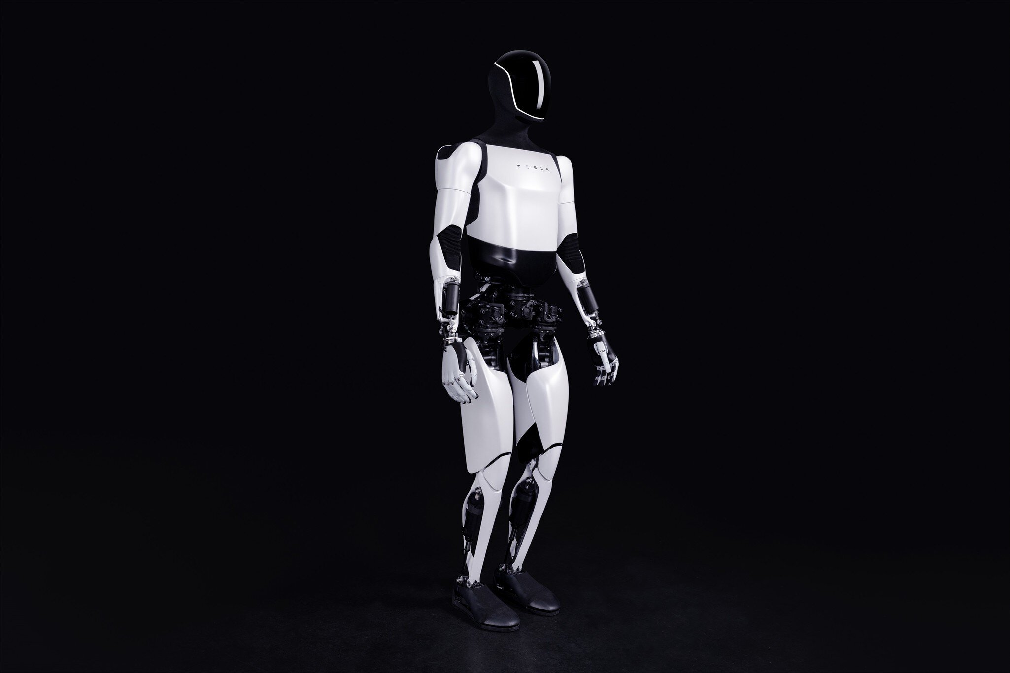 A humanoid robot with a shiny white and black exterior stands in front of a dark background.