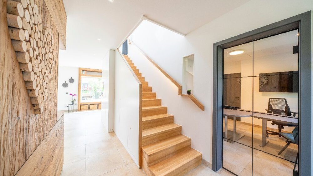 Modernes Interieur mit Holztreppe, Glasbürotür und dekorativer Holzblockwandstruktur.