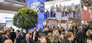 Menschen in einer Messehalle.