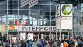Numerous visitors in front of the east entrance of Messe München with a large INTERFORST sign.