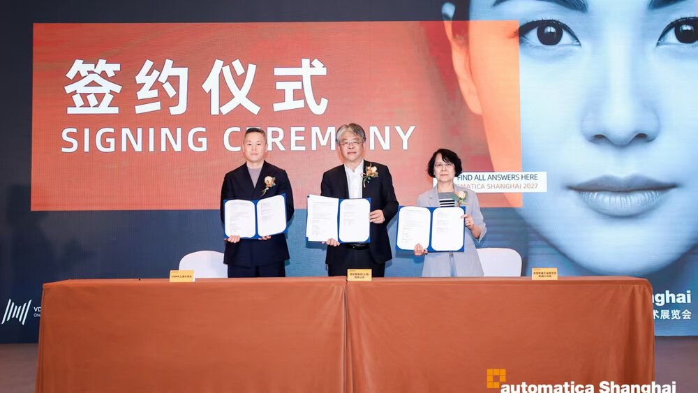 Three people present signed documents during a signing ceremony at automatica Shanghai on a stage.