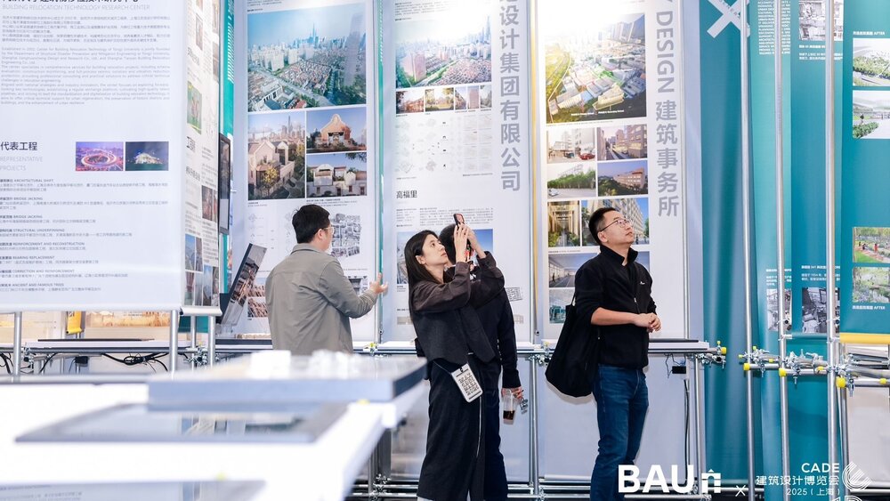 Eine Gruppe von Messebesuchern steht an einem Stand auf der BAU CHINA zwischen riesigen Informationstafeln und blickt hinauf.