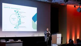 Speaker presenting DuploTEC SBF structural bonding films at the LOPEC conference in front of an audience