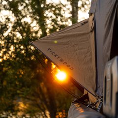 Ein VICKYWOOD Dachzelt steht im Sonnenlicht am Waldrand und zeigt komfortables Camping inmitten der Natur. Das Bild passt zur Podcast-Folge über Dachzelte und Outdoor-Abenteuer auf der f.re.e.