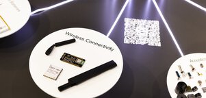 Wireless connectivity components displayed on a white platform with glowing lines and a QR code in the background.