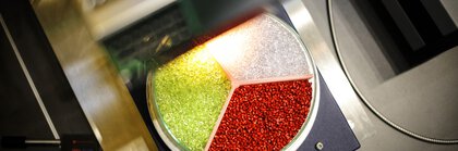 Eine dreigeteilte Petrischale gefüllt mit roten, grünen und transparenten Teilchen in einem Analysegerät