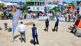 Demonstration of various machines in the outdoor area. A barrier and audience can be seen in the background.