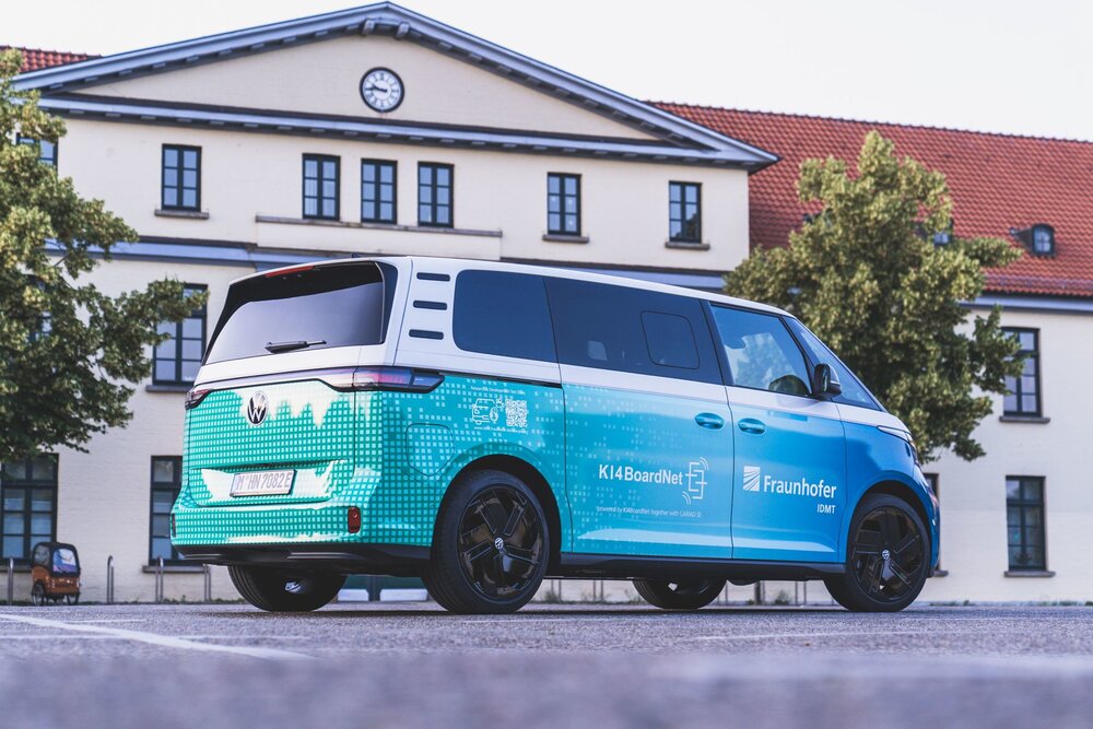 Electric VW ID. Buzz with Fraunhofer branding and KI4BoardNet label in front of an institute building