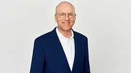 In the photo, you can see Dr. Pfeiffer, CEO of Messe München Group, wearing a suit and smiling.