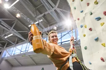 Visitor climbing the climbing tower at f.re.e 2025, showcasing her climbing skills