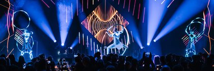 Three artists perform a show with lights and hoops on stage at the INHORGENTA AWARD in front of an audience.