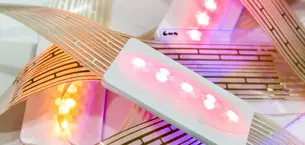 Close-up of glowing LED lights mounted on strips of printed plastic film.