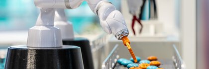 ein Roboterarm interagiert mit bunten Tabletten