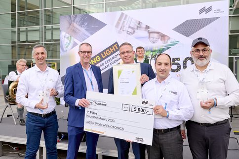Eine Gruppe von fünf Männern hält einen großen Scheck und eine Auszeichnung vom Innovation Award 2023.