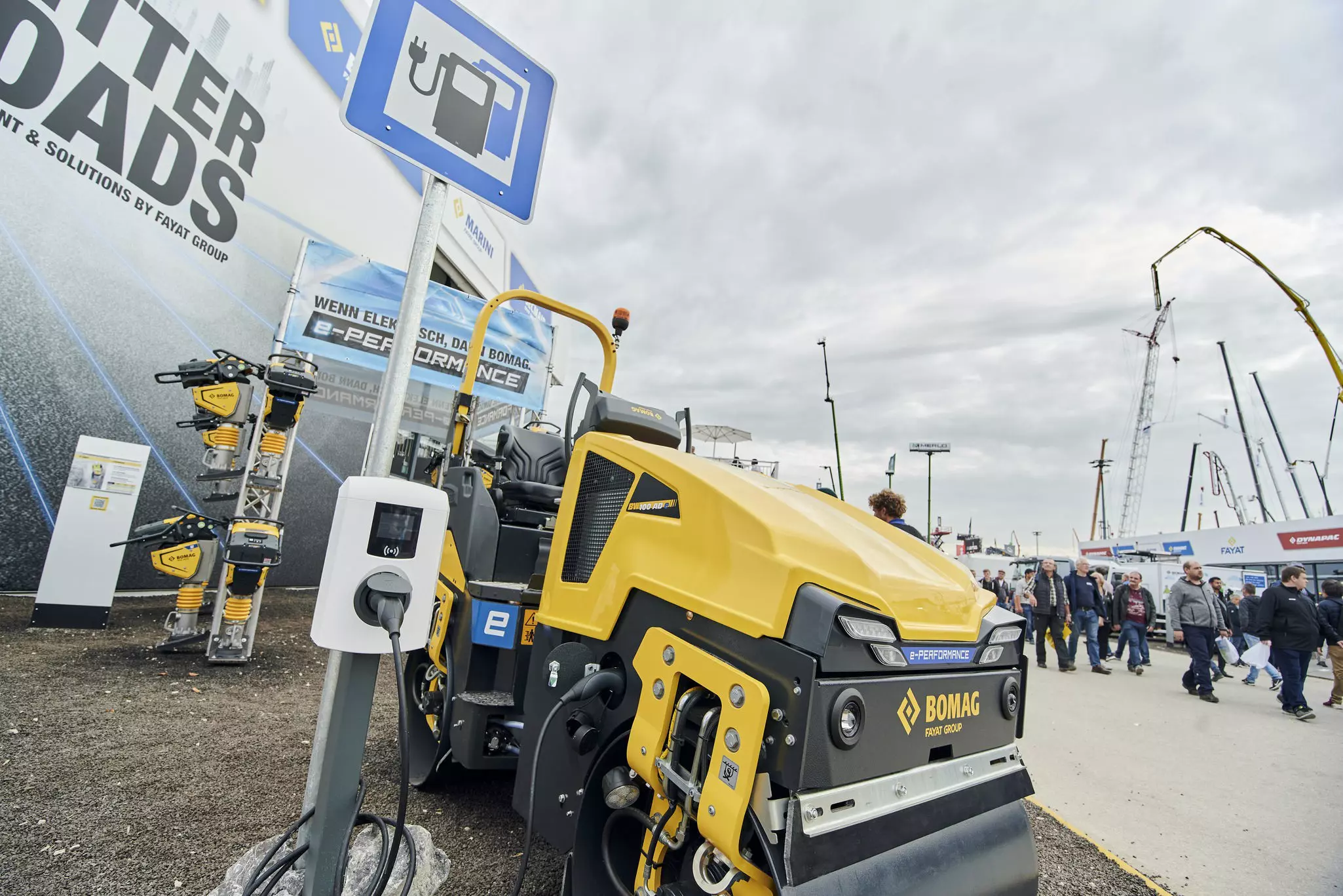  The BOMAG stand at bauma 2022 shows an electrically powered construction machine being charged.