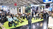 Man with microphone speaking to a large audience in the Startup Area at IFAT Munich 2024.