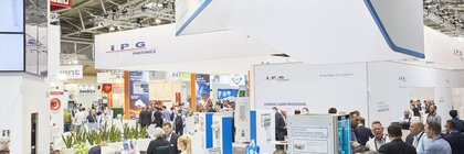 Menschen, zwischen gut besuchten Messeständen in einer hell beleuchteten Messehalle mit dem roten Schild A3.