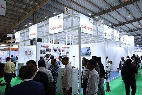 An exhibition stand at a ceramitec event with numerous visitors chatting and gathering information in front of it.