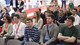 Several spectators sit on chairs during ceramitec and watch a presentation that takes place outside the picture.