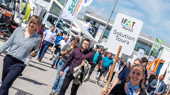 Teilnehmer der IFAT Munich Lösungstour laufen über das Messegelände der IFAT Munich auf dem Weg zu einem Aussteller