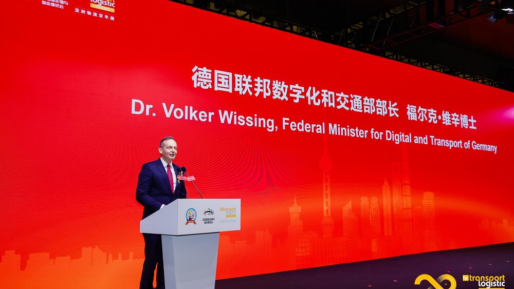 A man in a suit stands at a podium at 