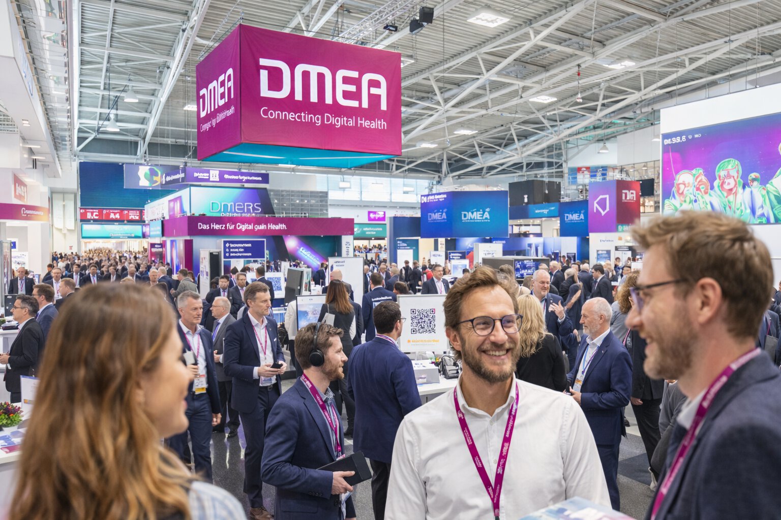 Busy DMEA exhibition hall with professionals networking and digital health booths
