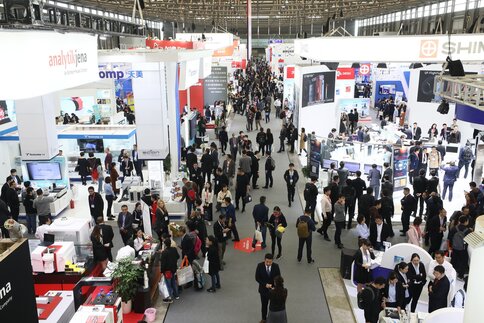Große Messehalle mit dicht gefüllten Gängen, zahlreichen Ausstellerständen zu Labor- und Messtechnik sowie vielen Besucherinnen und Besuchern, die sich informieren und austauschen.