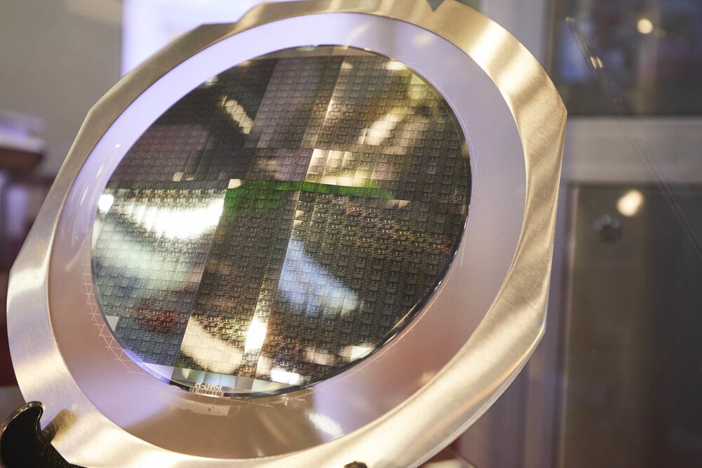 A round construction with a metal frame and many small rectangular, shimmering semiconductor boards.
