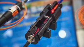 Close-up of a cross-sectional model of a laser exhibited at a trade fair stand.