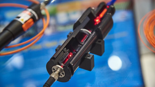 Close-up of a cross-sectional model of a laser exhibited at a trade fair stand.