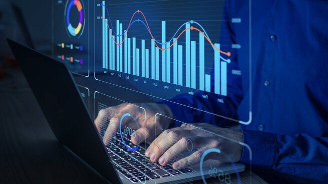 Person tippt auf einem Laptop, überlagert mit digitalen Diagrammen und Grafiken, die Datenanalysen und Statistiken zeigen.
