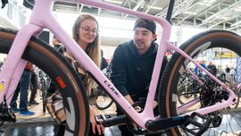 Zwei Personen schauen auf rosafarbenes CUBE Fahrrad