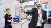 Trade fair visitor tests a virtual reality application at an exhibition booth.