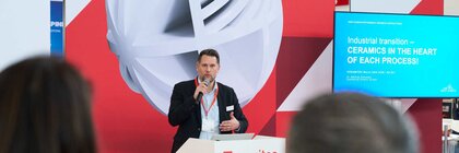 Speaker giving a presentation on the ceramitec stage in front of an audience.
