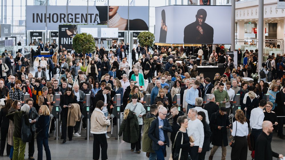 Eine große Menschenmenge betritt eine Ausstellungshalle mit INHORGENTA-Schildern und modernen Displays im Hintergrund.