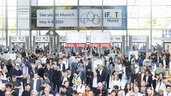 People stream through the revolving doors into the IFAT Munich entrance hall.