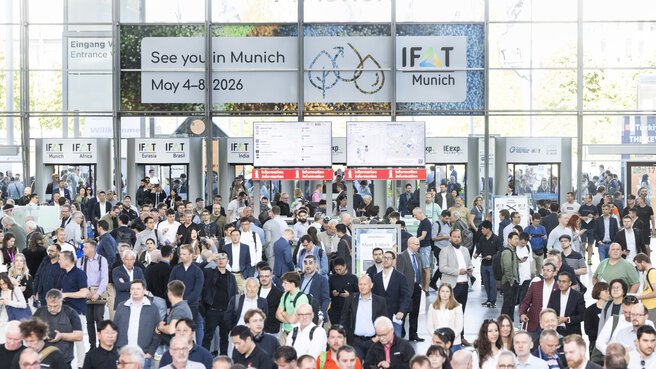 People stream through the revolving doors into the IFAT Munich entrance hall.