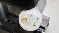 Close-up of an exposed microchip enclosed in a plexiglass puck for presentation.
