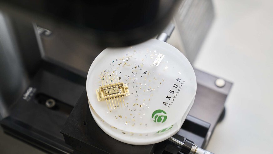 Close-up of an exposed microchip enclosed in a plexiglass puck for presentation.