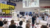 Visitors at the analytica trade fair are watching the “Special Show Live Lab,” where experts in lab coats demonstrate equipment and applications live.