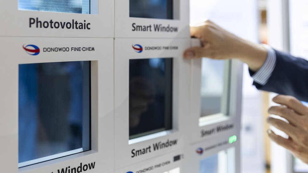 Nahaufnahme von Händen, die nach einem Segment mit der Bezeichnung „Smart Window“ greifen. Im Vordergrund sind weitere Segmente zu sehen.