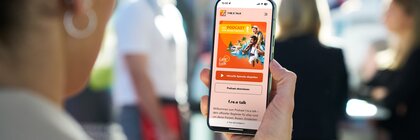 A person looks at the cell phone display showing the free podcast