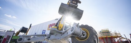 Geländegängige Baumaschine mit Schaufel bei Live-Demonstration im Freigelände.