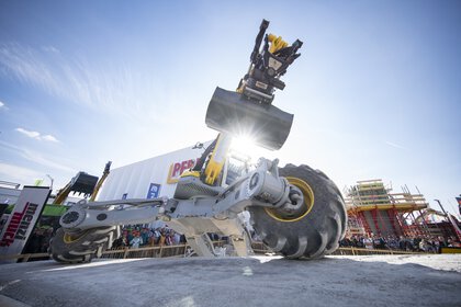 Geländegängige Baumaschine mit Schaufel bei Live-Demonstration im Freigelände.